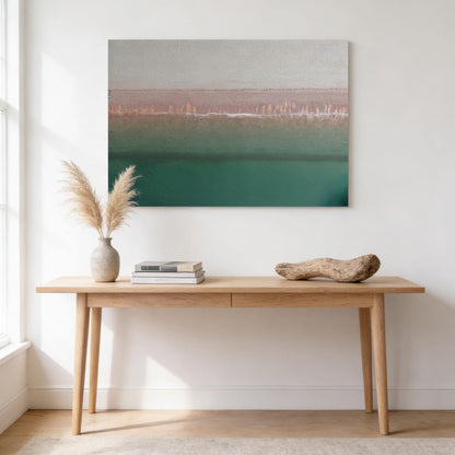 a wooden table with a stack of books and a potted plant on it, set against a white wall with a framed landscape painting hanging above.